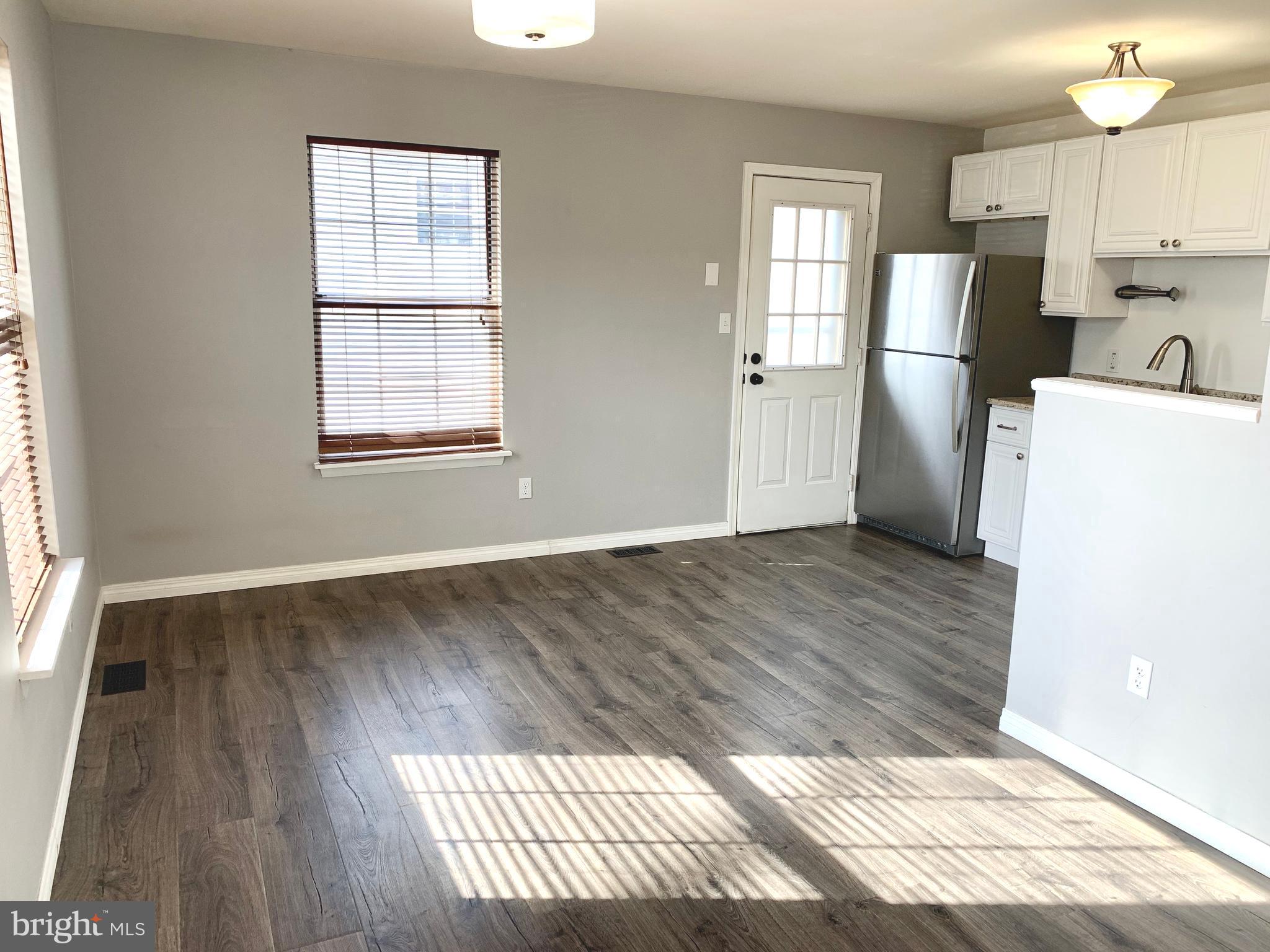 808 207th Street Pasadena, MD 21122 - Photo 7 of 20 an empty room with wooden floor and windows