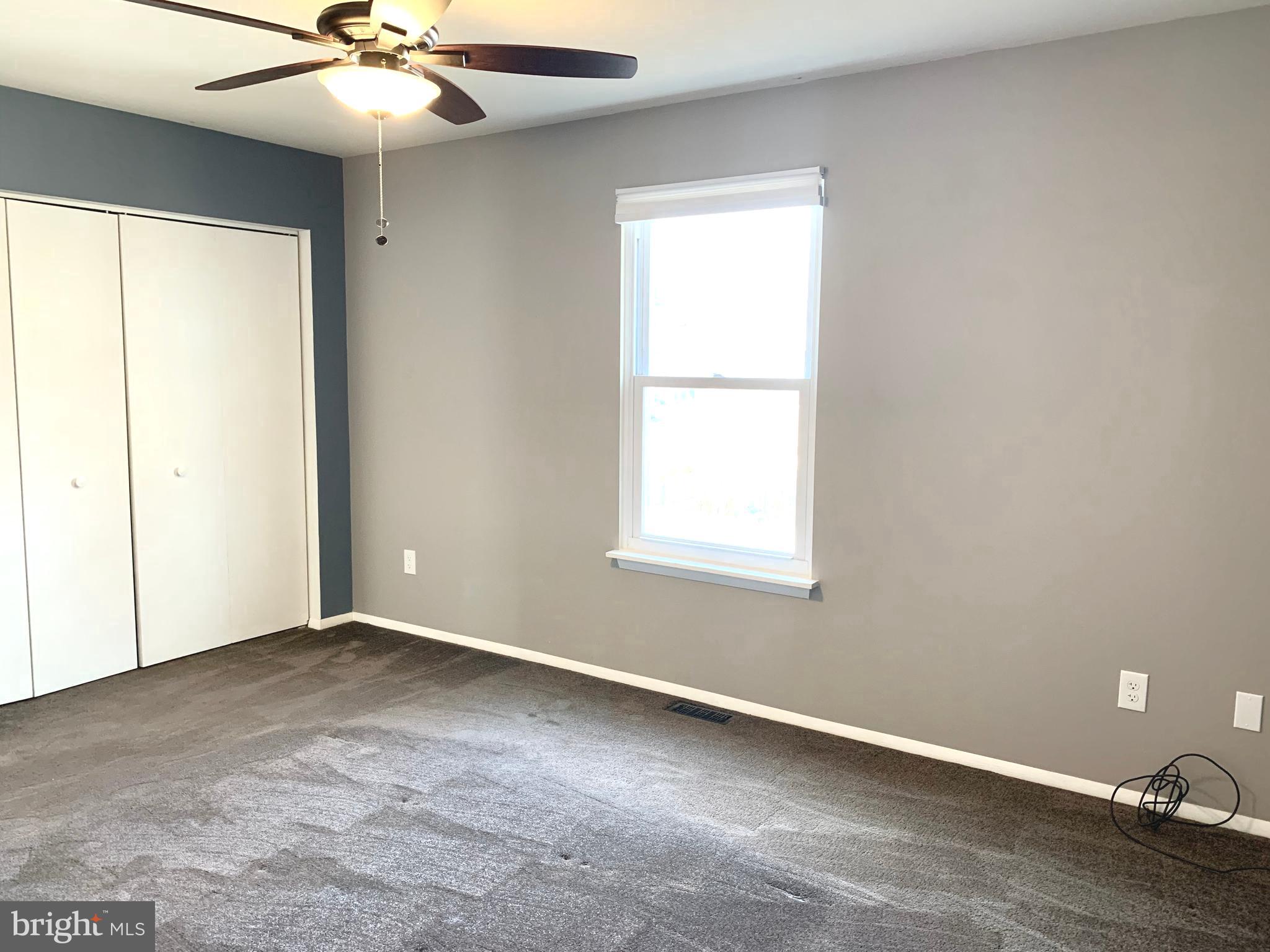 808 207th Street Pasadena, MD 21122 - Photo 9 of 20 an empty room with a window and a fan