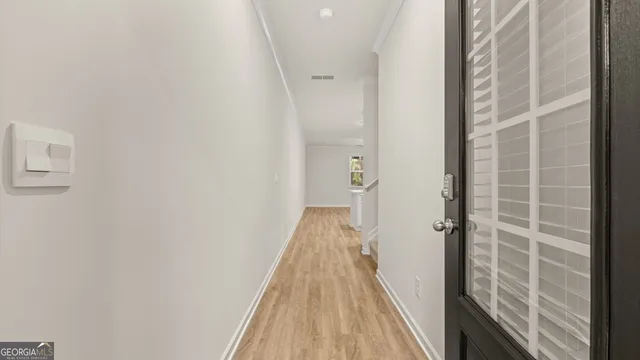 an empty room with a chandelier fan and windows