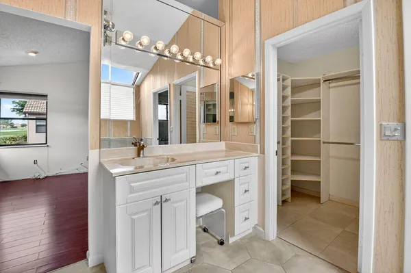 a bathroom with a tub shower sink vanity granite and a shower