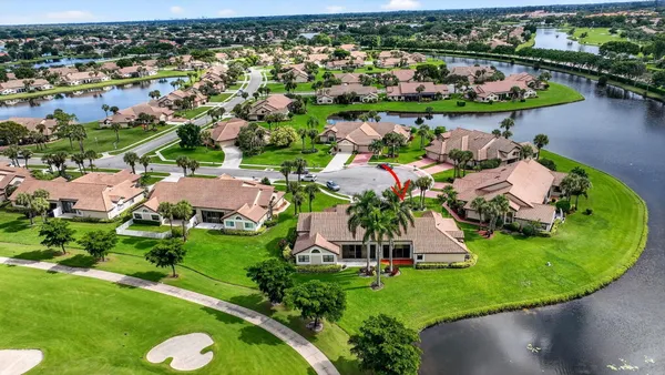 an aerial view of a house with a yard and lake view