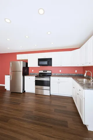 a kitchen with stainless steel appliances a stove and wooden floor