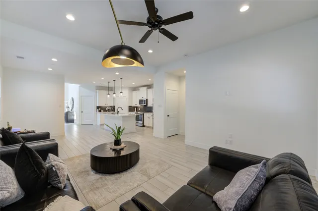 a living room with furniture and kitchen chandelier