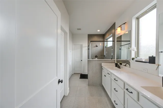 a bathroom with a double vanity sink mirror and shower