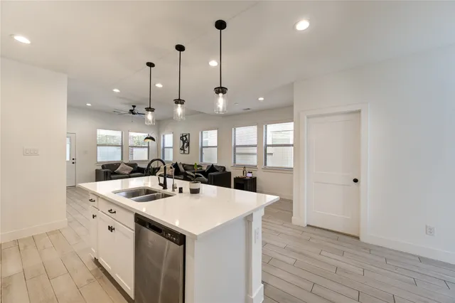 a kitchen with a sink a stove a refrigerator and white cabinets