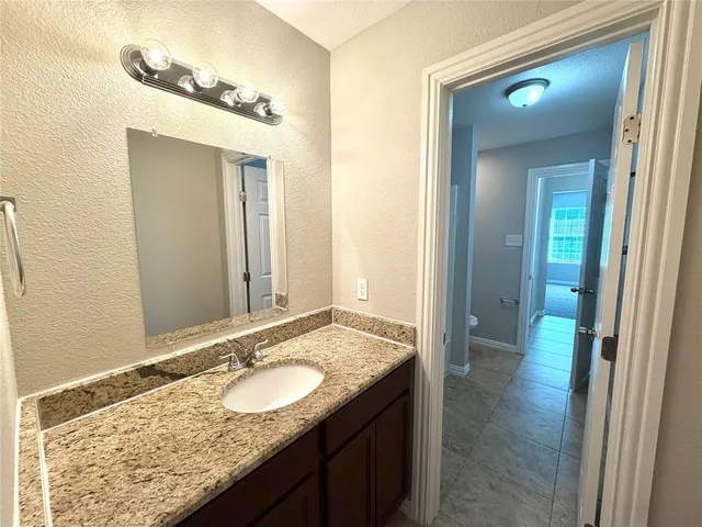 a bathroom with a granite countertop sink and a mirror