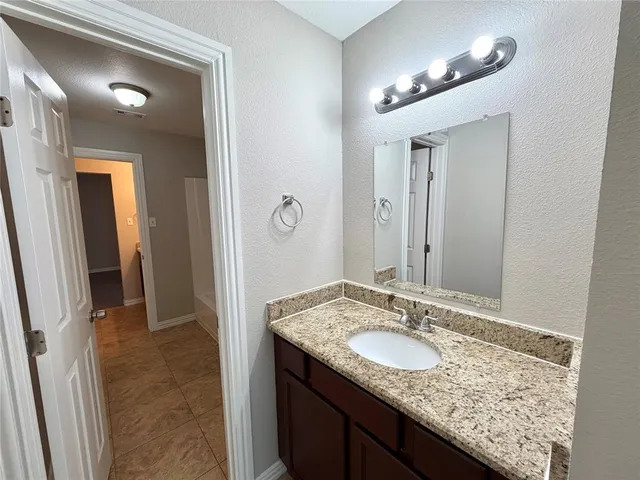 a bathroom with a granite countertop sink and a mirror