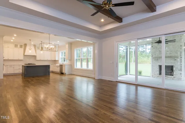 a view of an empty room with a fireplace and a window