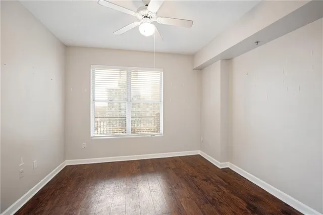 a view of a hallway with wooden floor and closet area