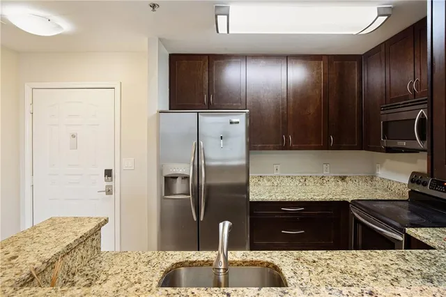 a kitchen with stainless steel appliances granite countertop cabinets and refrigerator