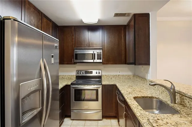 a kitchen with stainless steel appliances granite countertop a refrigerator and a sink