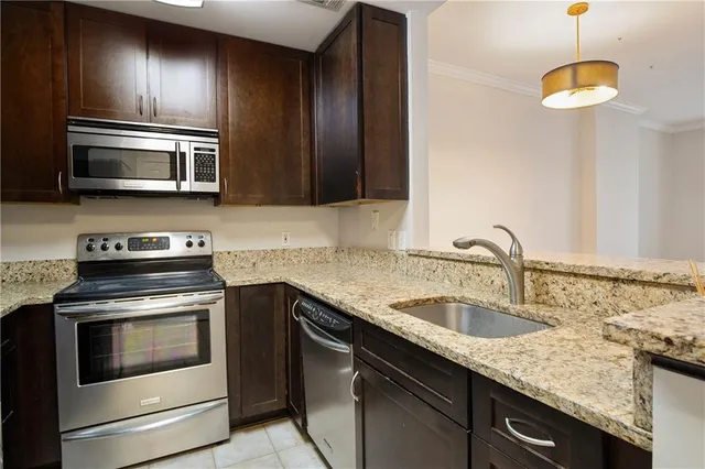 a kitchen with stainless steel appliances granite countertop a sink and stove top oven