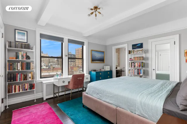 a bedroom with a large bed a book shelf and a window