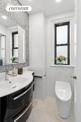 a bathroom with a sink a toilet and mirror