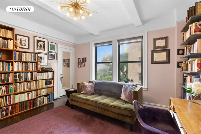 a living room with furniture and a book shelf