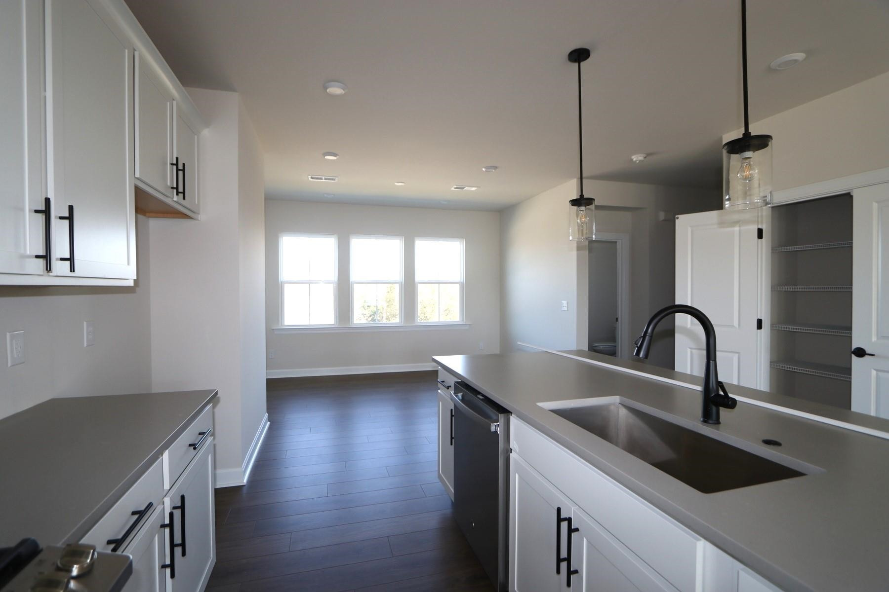 716 Icarus Lane Wake Forest, NC 27587 - Photo 3 of 5 a kitchen with kitchen island a sink stainless steel appliances and windows