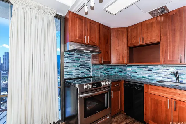 a kitchen with stainless steel appliances granite countertop a stove sink and cabinets