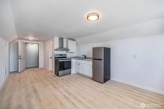 a kitchen with granite countertop a refrigerator stove and oven