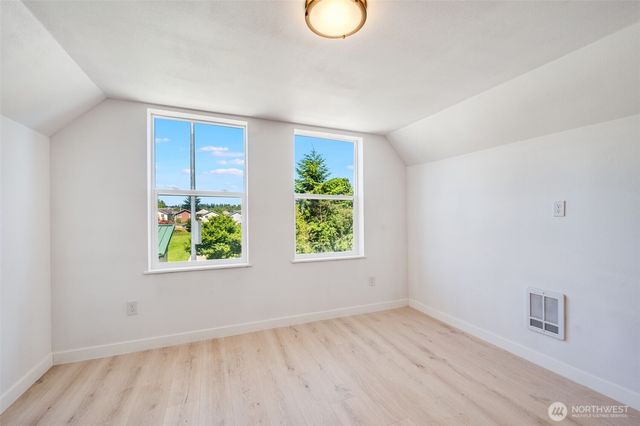 an empty room with window and wooden floor