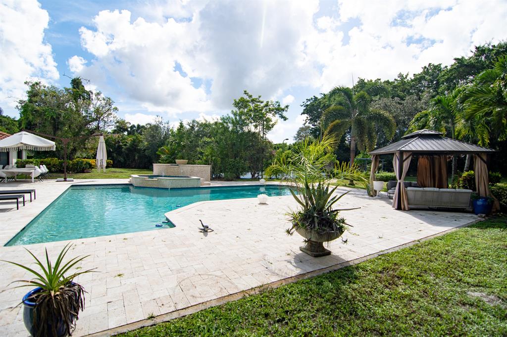 8208 Twin Lake Drive Boca Raton, FL 33496 - Photo 30 of 53 a view of a swimming pool with a patio and a yard