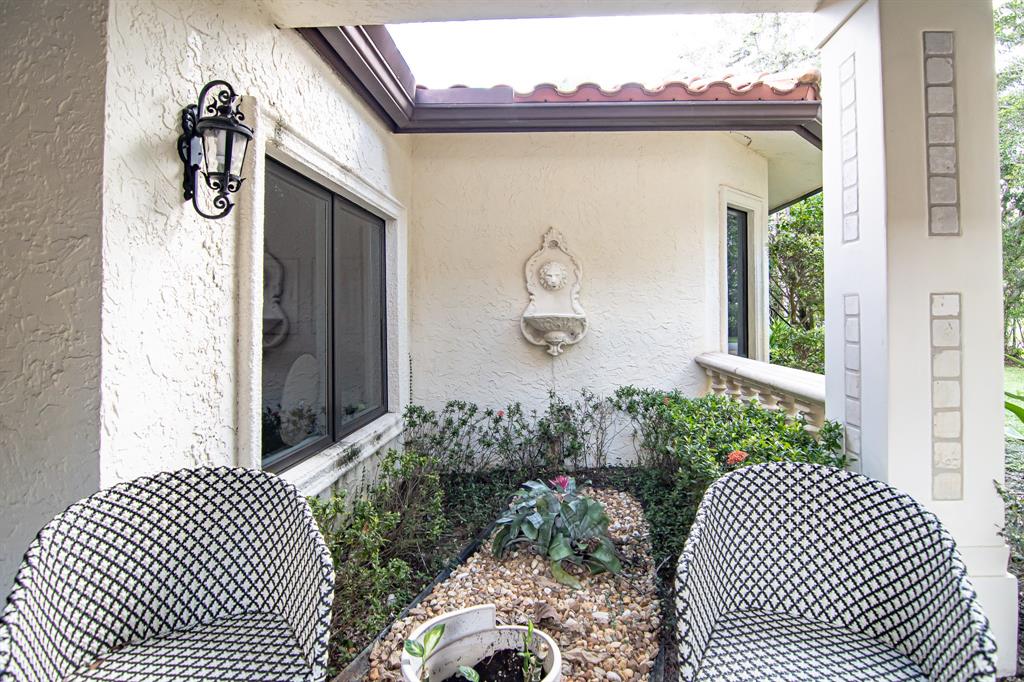 8208 Twin Lake Drive Boca Raton, FL 33496 - Photo 44 of 53 a front view of a house with a garden