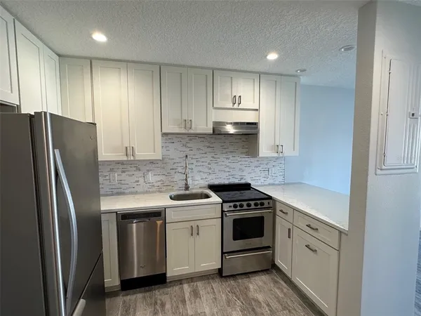 a kitchen with a refrigerator sink and cabinets