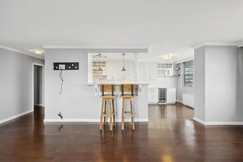 a view of an empty room with wooden floor and a cabinet