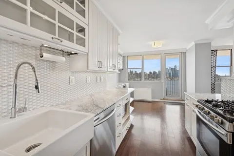 a kitchen with stainless steel appliances granite countertop a refrigerator and a stove top oven