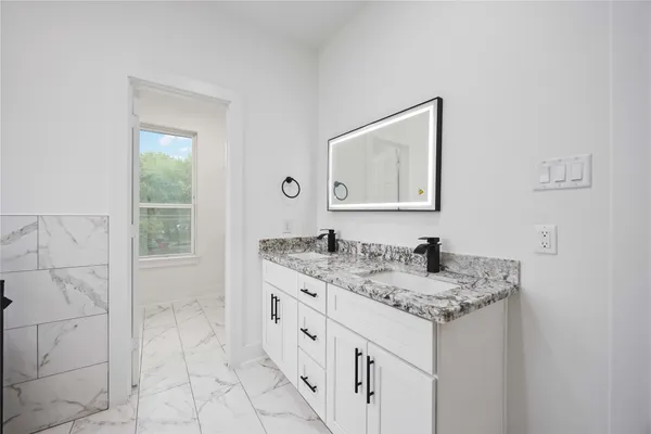 a bathroom with a granite countertop sink a toilet and mirror