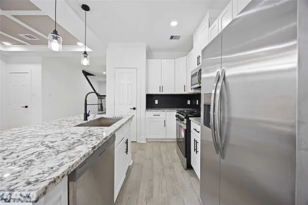 a kitchen with kitchen island a counter top space appliances and a refrigerator