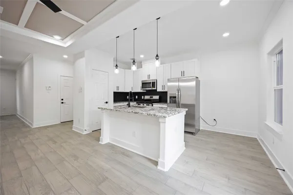 a view of kitchen with stainless steel appliances granite countertop cabinets and wooden floor