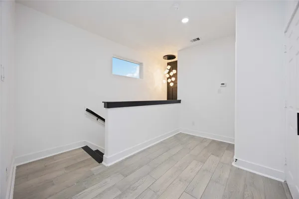 a view of an empty room with wooden floor
