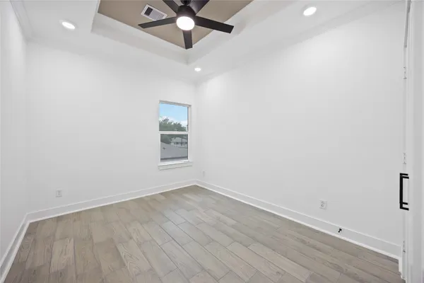 an empty room with a window and a ceiling fan