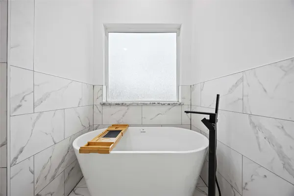 a bathroom with a white bath tub and shower