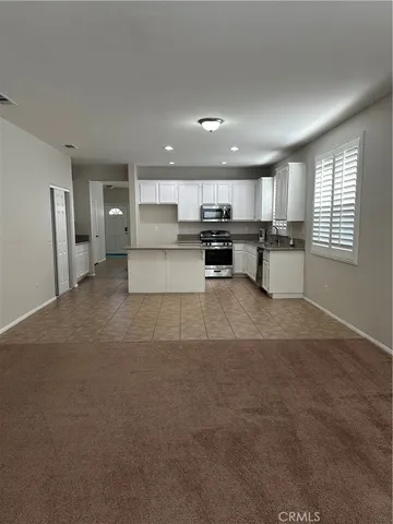 a large kitchen with kitchen island a sink stainless steel appliances and cabinets