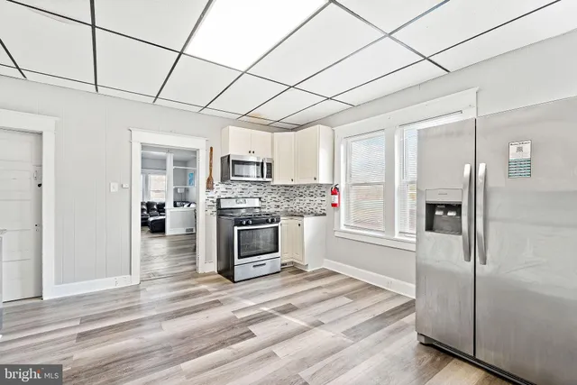 a kitchen with granite countertop a refrigerator and a stove top oven