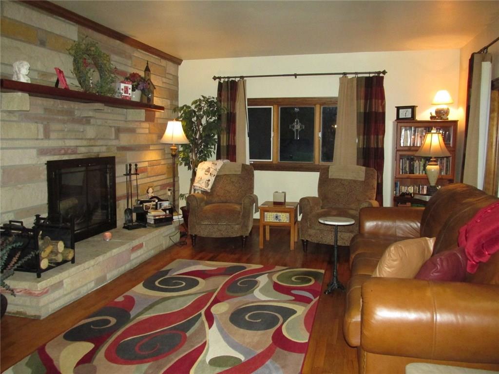 392 Maple Summit Road Mill Run, PA 15464 - Photo 8 of 25 Wood burning fireplace number two! How about those stunning refinished hardwood floors! The stone faced wall runs the entire length of the living room as you'll see next.