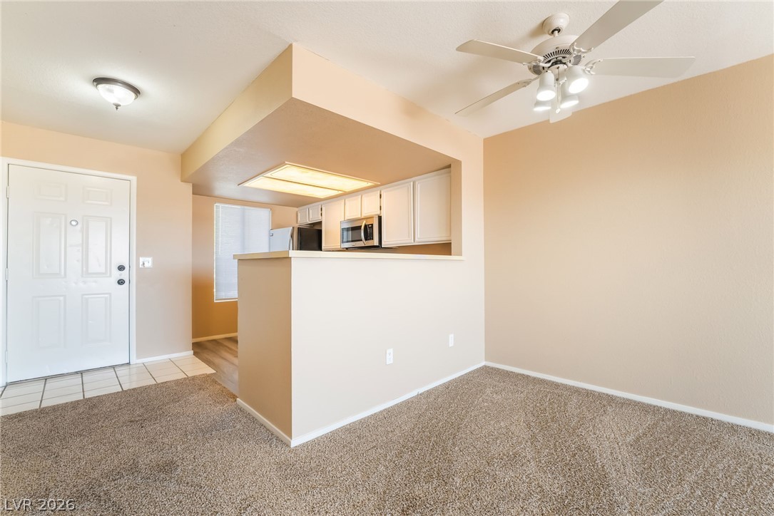 8070 West Russell Road, Unit 2024 Las Vegas, NV 89113 - Photo 6 of 19 An inviting open-concept living space features a kitchen pass-through and a comfortable carpeted area.