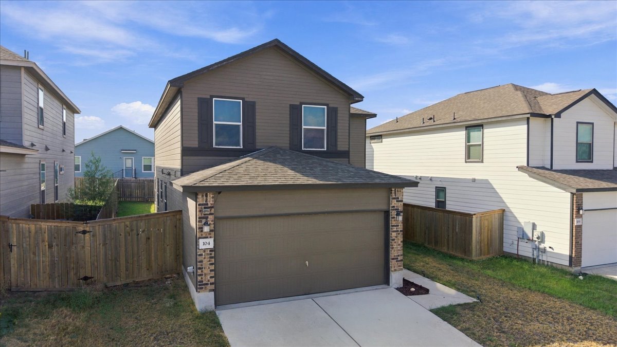 Clean architectural lines define this two-story exterior featuring a spacious driveway and integral garage.
