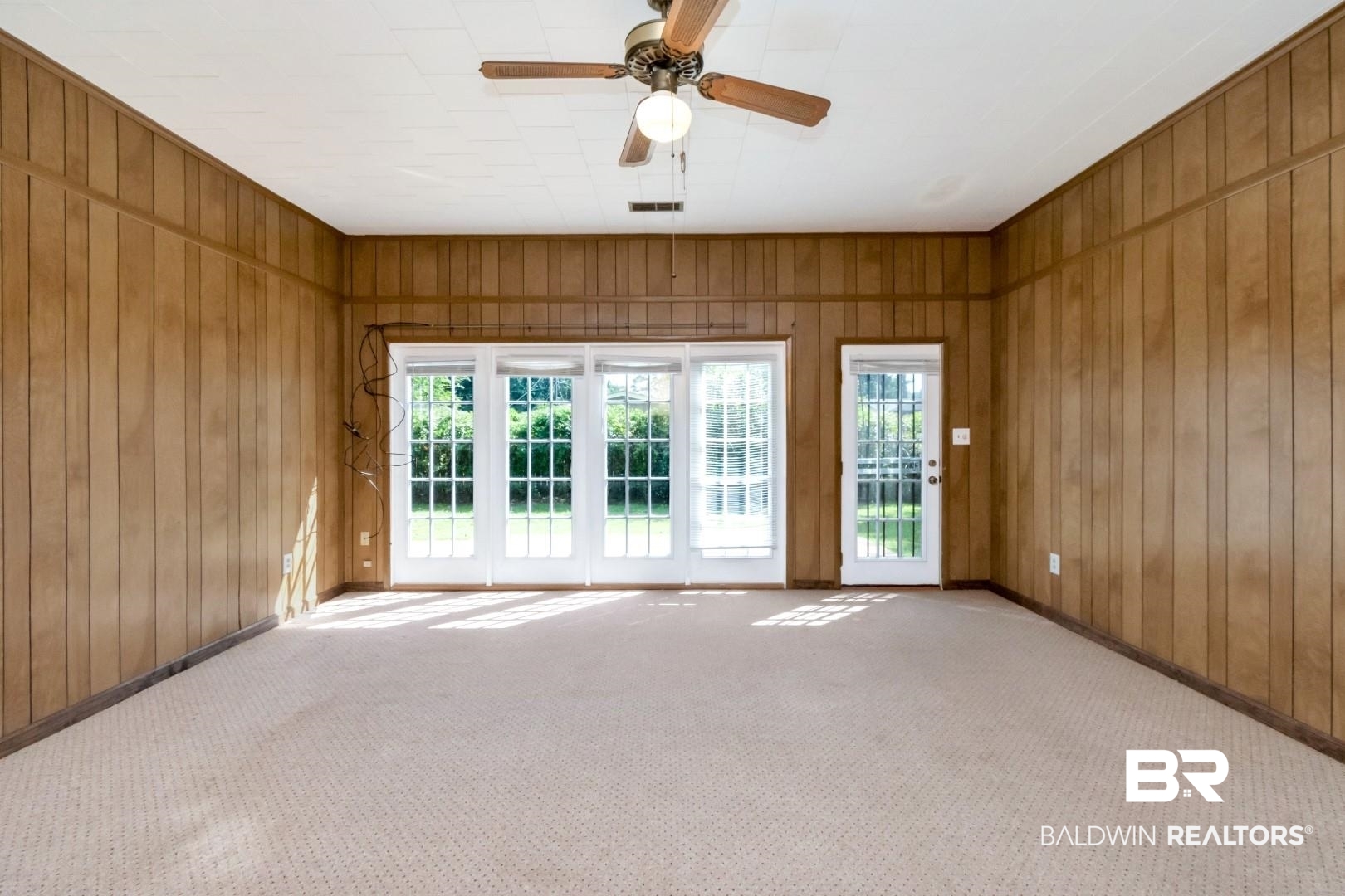 1477 Fairfield Street Mobile, AL 36606 - Photo 24 of 34 Spare room featuring carpet flooring, a ceiling fan, and wooden walls