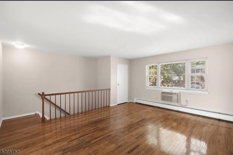 1251 Valley Road, Unit B Wayne, NJ 07470 - Photo 1 of 4 a view of an empty room with wooden floor and a window