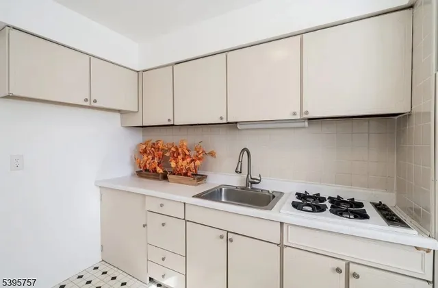 a kitchen with white cabinets and a stove with wooden floor
