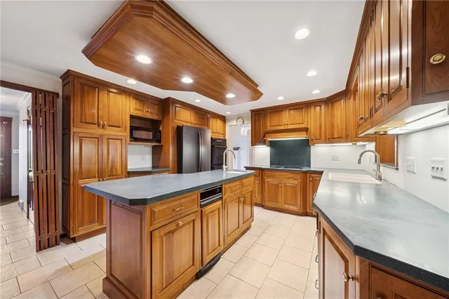 a kitchen with stainless steel appliances granite countertop a sink and a refrigerator