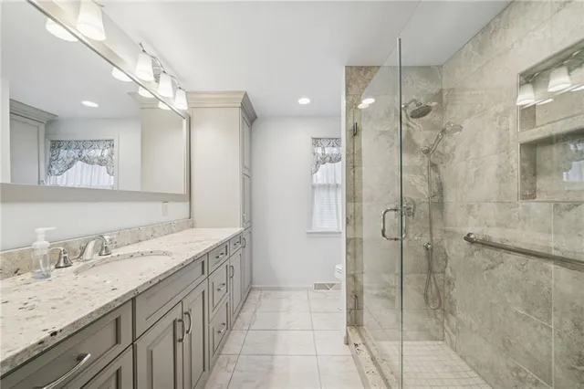 a bathroom with a granite countertop sink a shower and a mirror