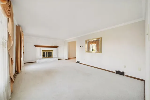 an empty room with windows and ceiling fan