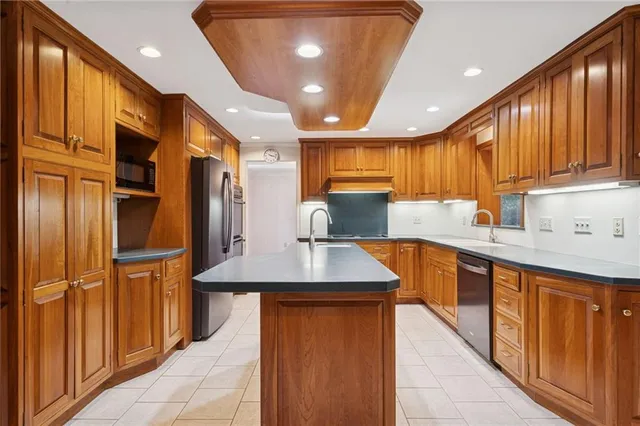 a kitchen with stainless steel appliances granite countertop a sink refrigerator and cabinets