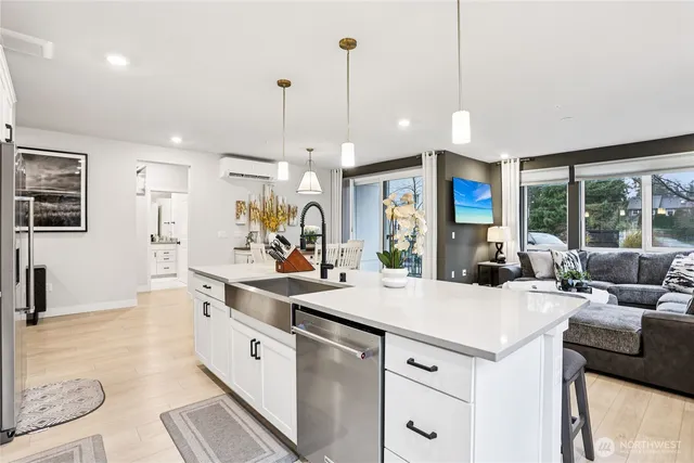 a large white kitchen with a large window and stainless steel appliances
