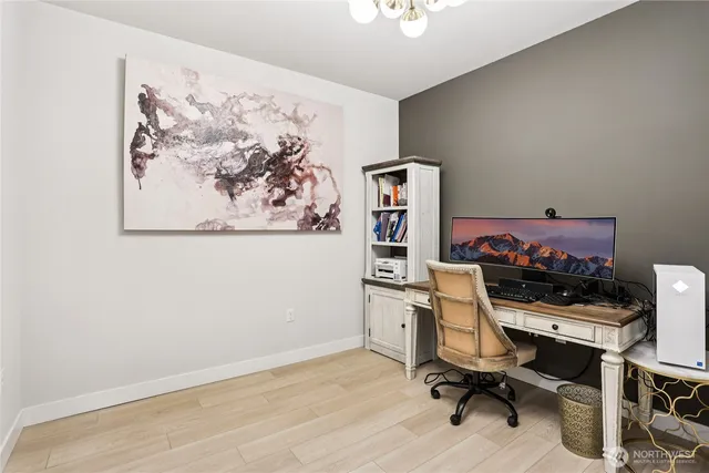 a view of a workspace with furniture and a window