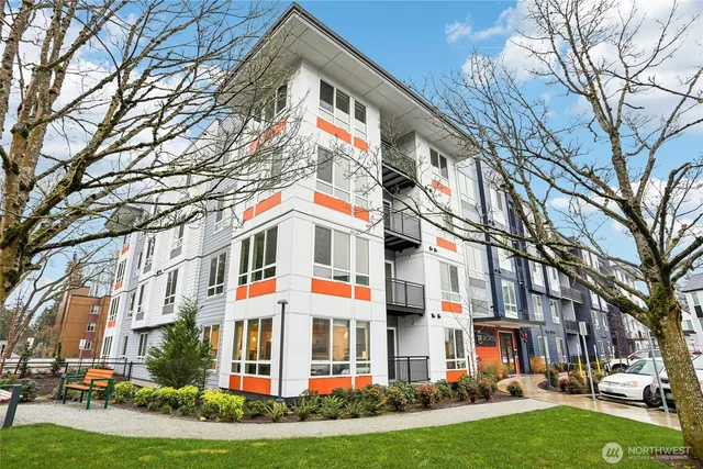 a front view of a residential apartment building with yard and green space
