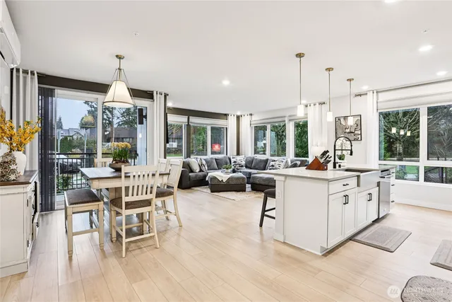 a living room with furniture a dining table wooden floor and a chandelier